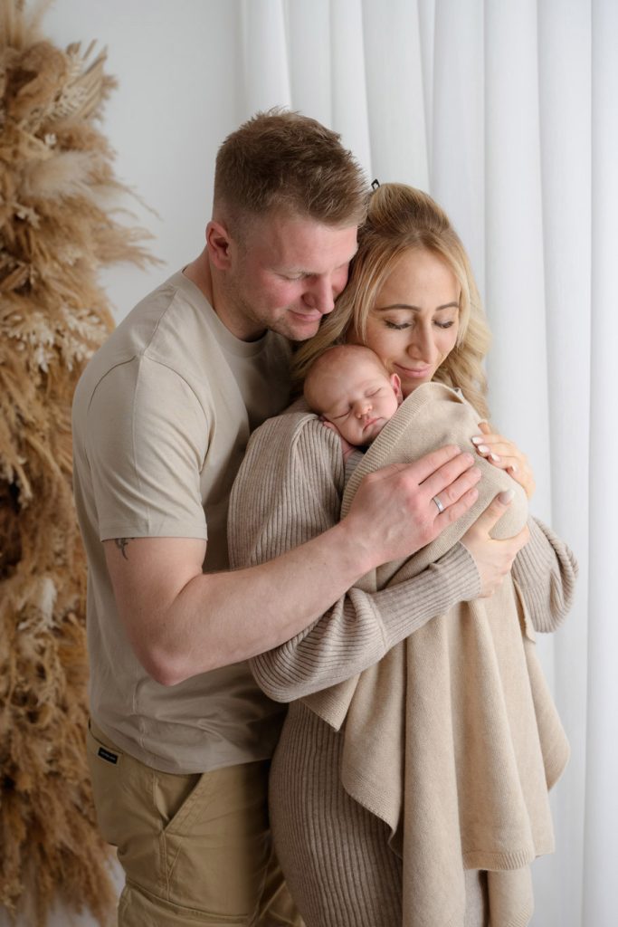 Neugeborenenfotografie im Raum Kiel und Gettorf – Baby liebevoll von seinen Eltern gehalten